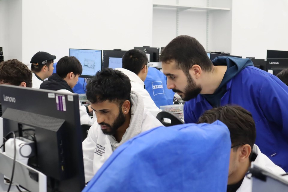 Several students gathered around computer screens in the laboratory.