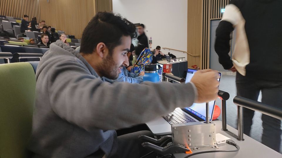 A student using workshop equipment while assembling a robot component.