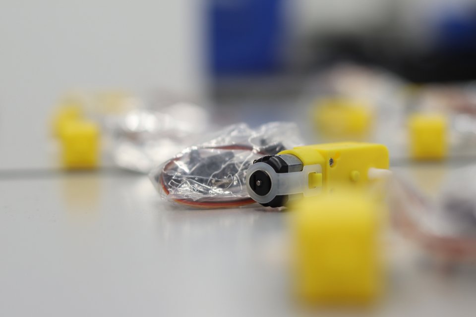 A yellow geared motor and wire pack surrounded by workshop components.