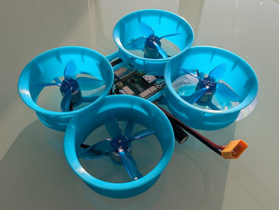 A blue ducted quadcopter with its flight controller and battery visible.