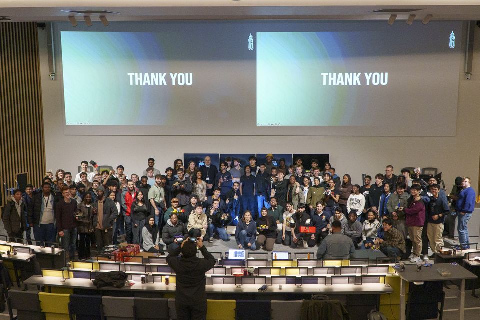 A large group of students gathered at the end of a robotics competition.