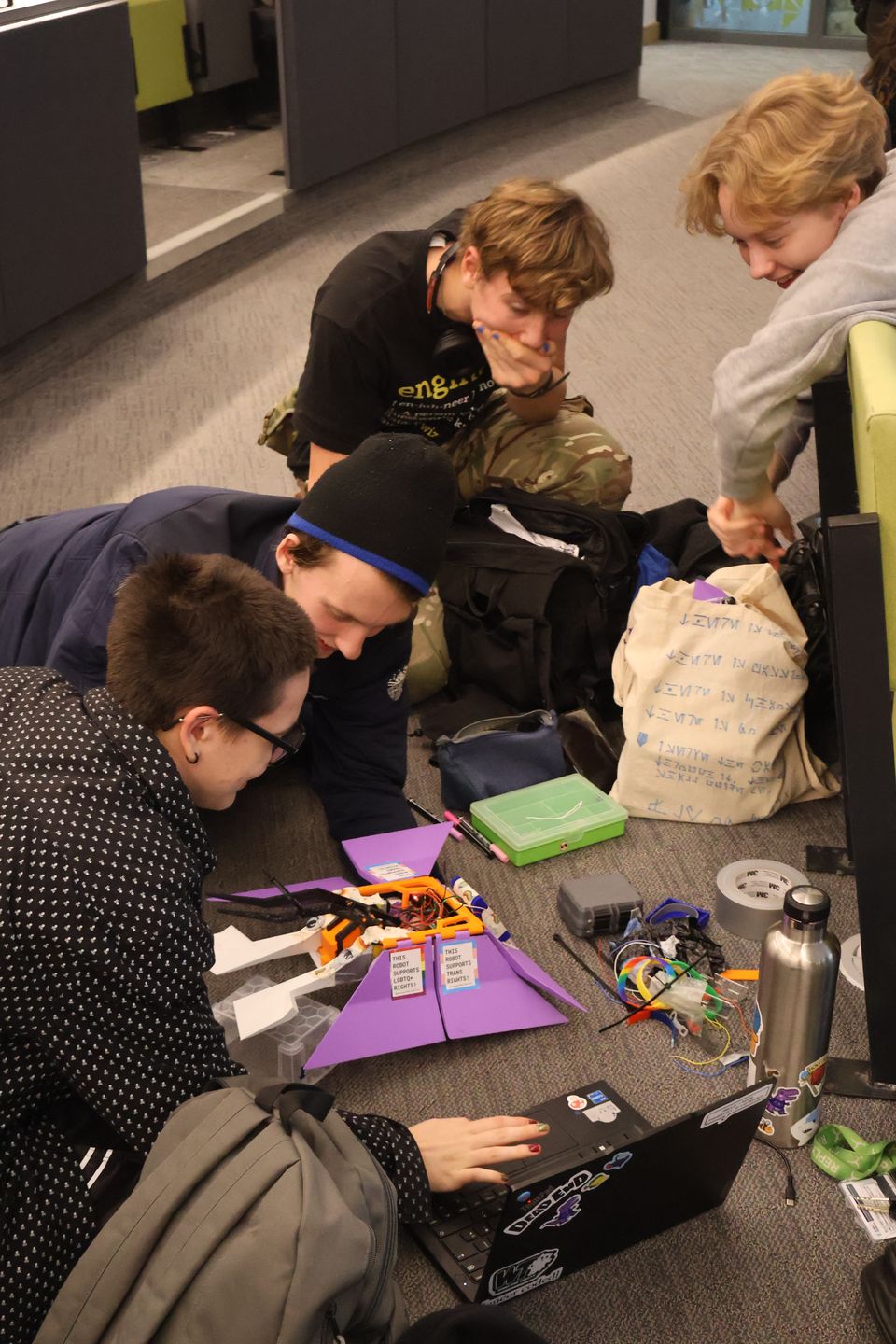 Students leaning over a table while working on an electronics project.