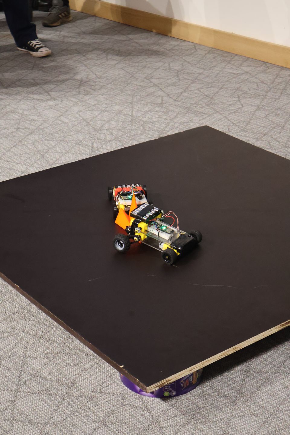 Two student-built robots driving toward one another in a match.