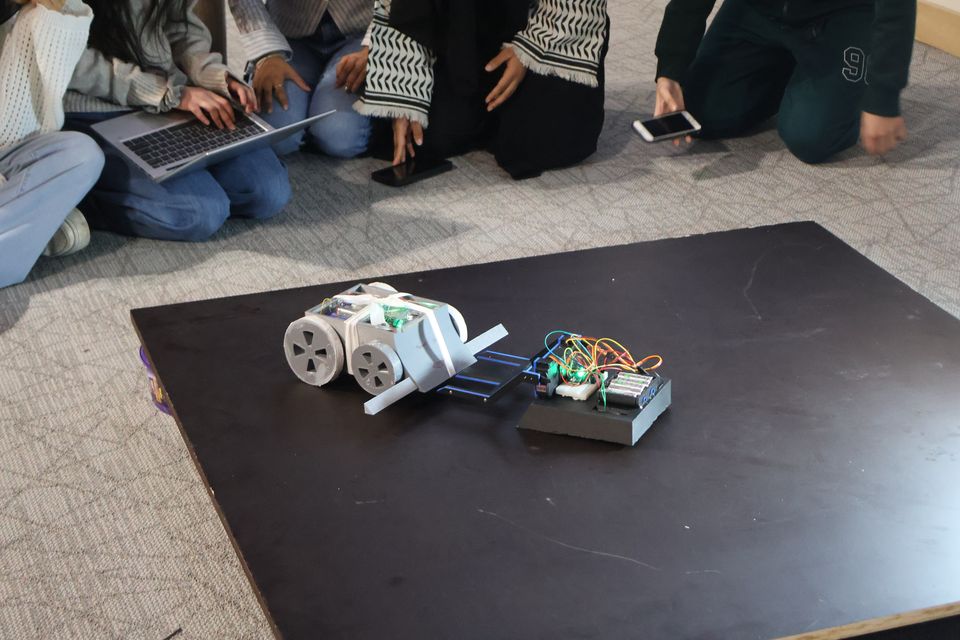 Two differently shaped robots facing off during a competition.