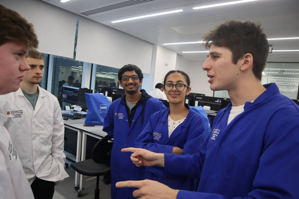 Three students discussing a workshop task in the laboratory.