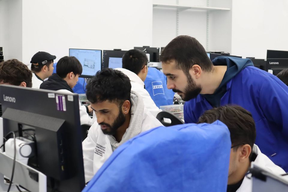 Several students gathered around computer screens in the laboratory.