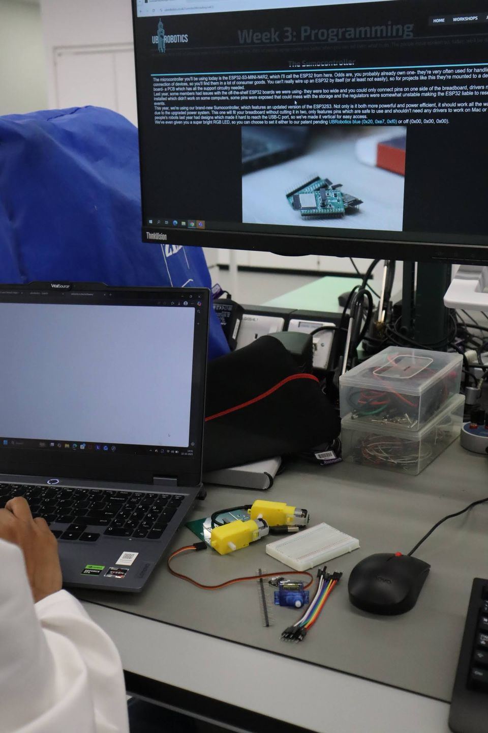 A laptop and electronic components arranged for testing on a workbench.