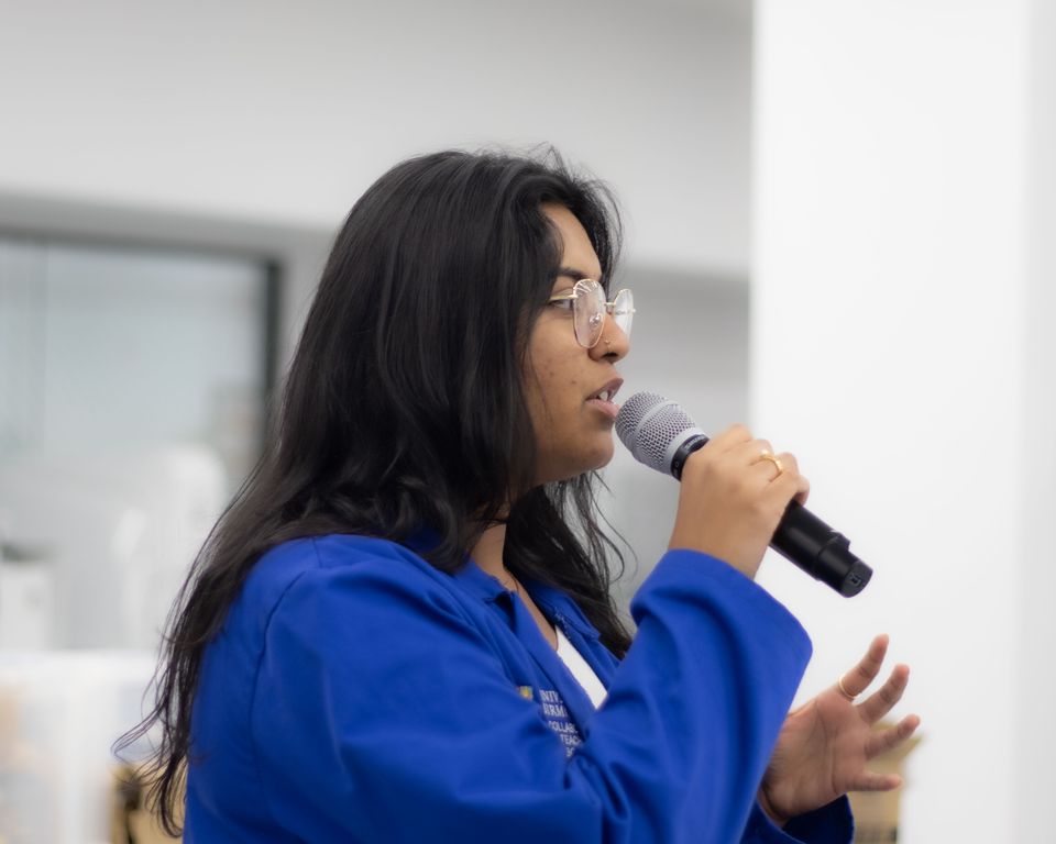 A student speaking into a microphone in the robotics laboratory.