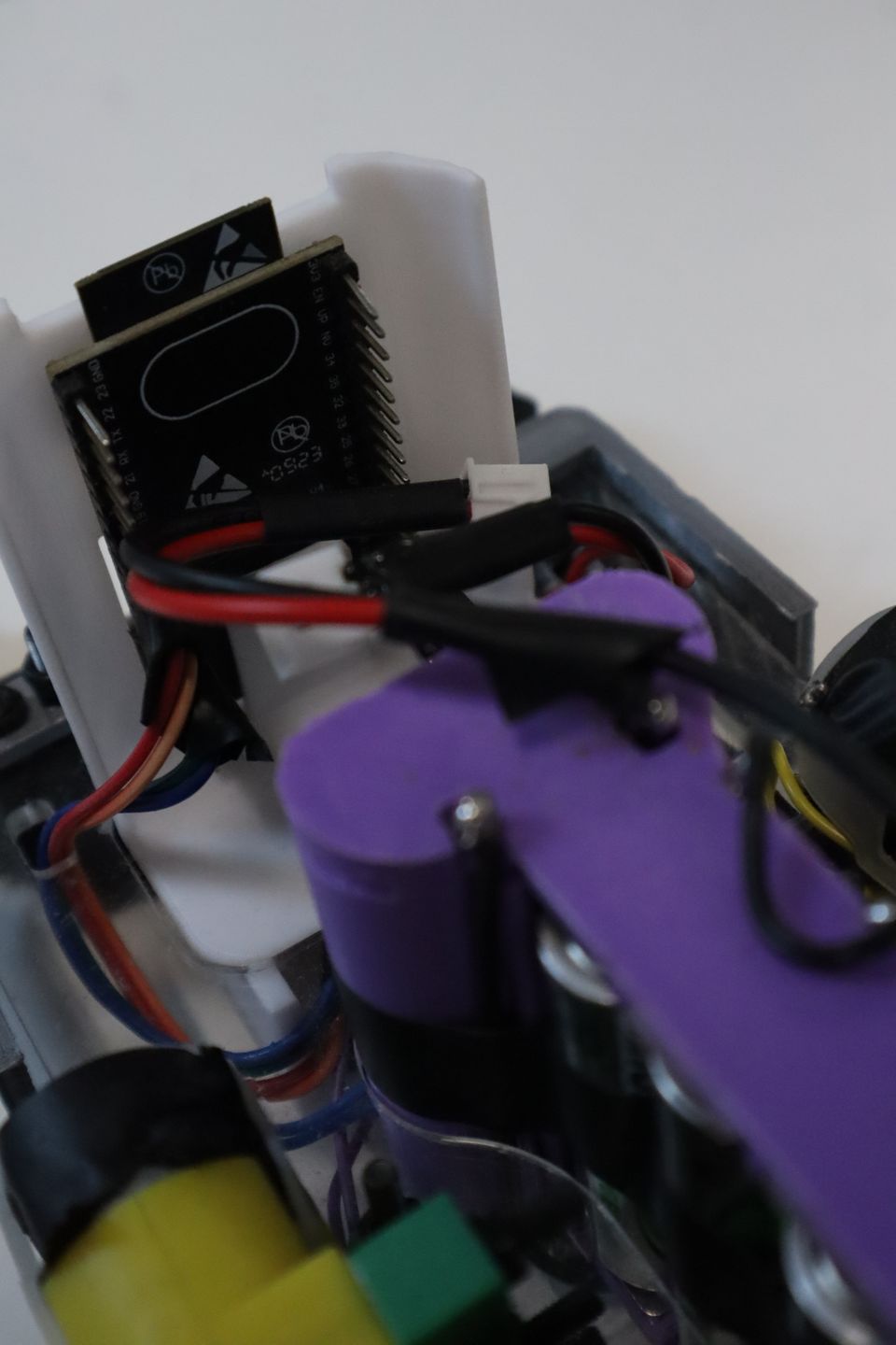 Close-up of a purple and black student-built wheeled robot.