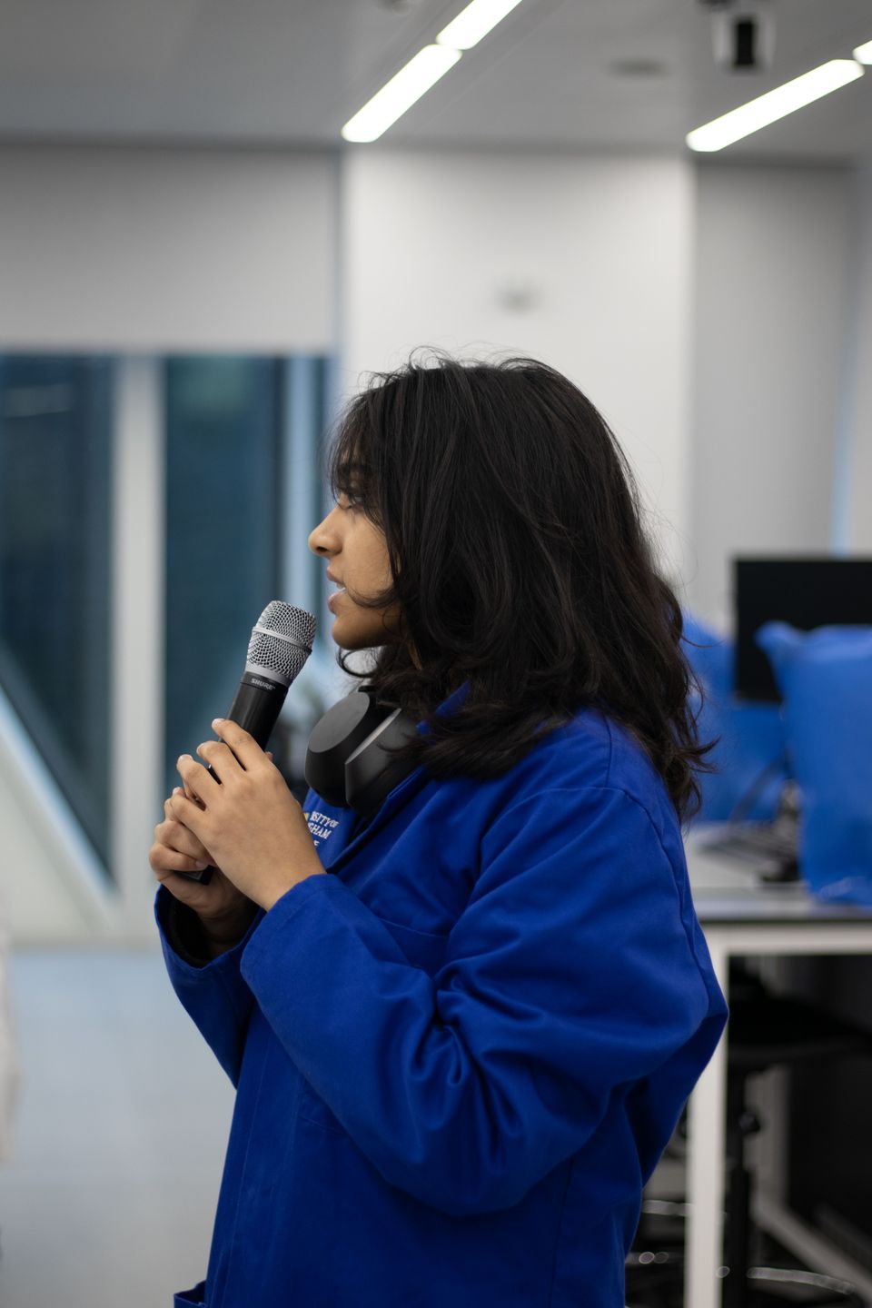 A student speaking to workshop participants with a microphone.
