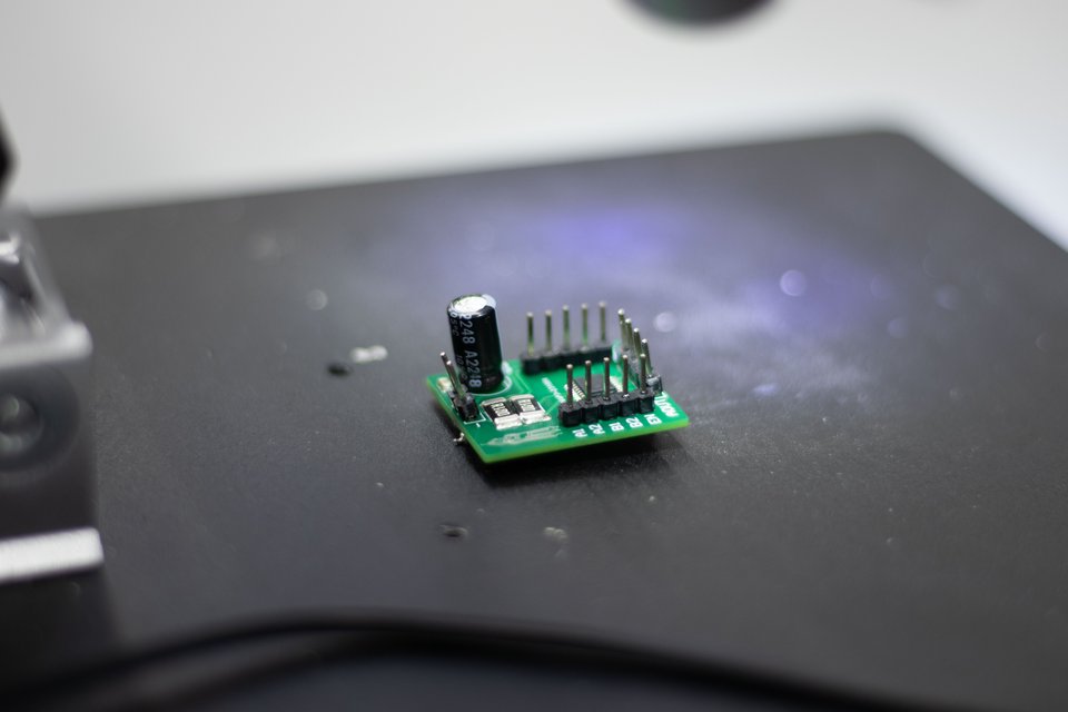 A completed green motor-driver board on a dark work surface.