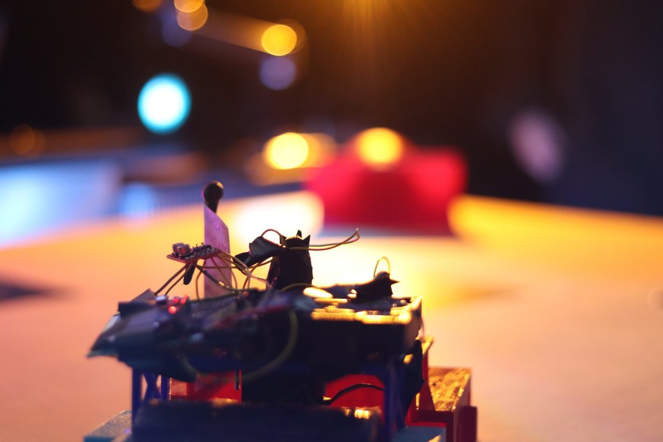A close view of a student-built Sumobot on an illuminated competition arena.